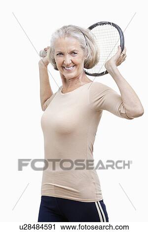 Portrait of senior woman holding tennis racket over her shoulder against white background View Large Photo Image Stock Image - Portrait of senior woman holding tennis racket over her shoulder against white background. Fotosearch
