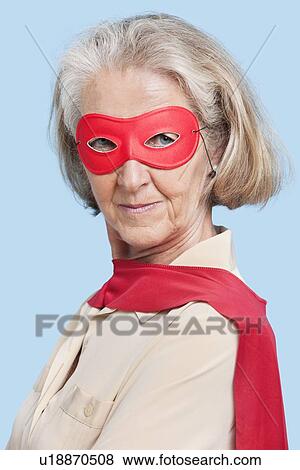 Portrait of senior woman wearing superhero costume against blue background View Large Photo Image Stock Photo - Portrait of senior woman wearing superhero costume against blue background. Fotosearch