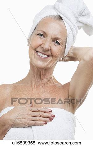 Stock Photography - Portrait of senior woman wrapped in towels against white background. Fotosearch