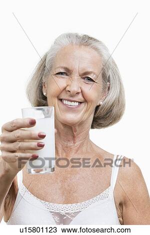 Portrait of smiling senior woman with a glass of milk against white background View Large Photo Image Stock Image - Portrait of smiling senior woman with a glass of milk against white background. Fotosearch