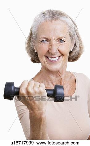 Portrait of smiling senior woman with dumbbell against white background View Large Photo Image Stock Photo - Portrait of smiling senior woman with dumbbell against white background. Fotosearch