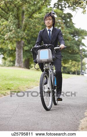 Portrait of young businessman commuting by his bicycle View Large Photo Image Stock Image - Portrait of young businessman commuting by his bicycle. Fotosearch