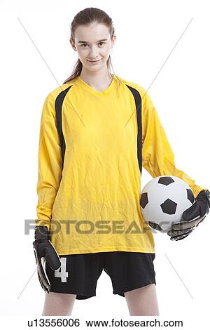 Stock Photograph - Portrait of young female soccer player with ball against white background. Fotosearch