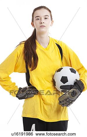 Portrait of young female soccer player holding ball with hand on hip against white background View Large Photo Image Stock Photograph - Portrait of young female soccer player holding ball with hand on hip against white background. Fotosearch