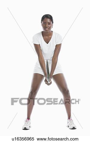 Portrait of young woman holding tennis racket standing over white background View Large Photo Image Stock Photography - Portrait of young woman holding tennis racket standing over white background. Fotosearch