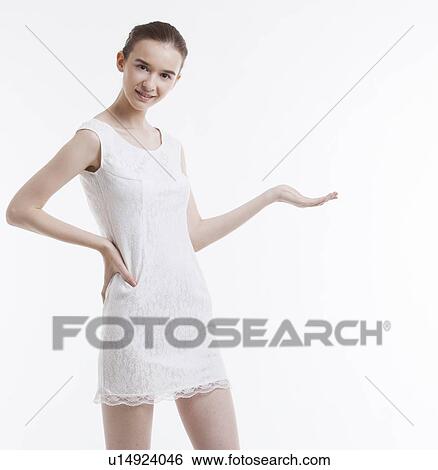 Portrait of young woman in dress with hand on hip over white background View Large Photo Image Stock Photograph - Portrait of young woman in dress with hand on hip over white background. Fotosearch