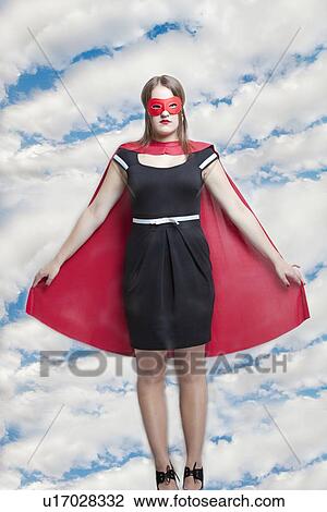 Portrait of young woman in superhero costume against cloudy sky View Large Photo Image Stock Image - Portrait of young woman in superhero costume against cloudy sky. Fotosearch