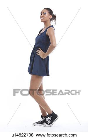Portrait of young woman wearing mini dress and sneakers against white background View Large Photo Image Stock Photo - Portrait of young woman wearing mini dress and sneakers against white background. Fotosearch