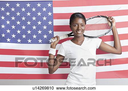 Portrait of young woman with tennis racket against American flag View Large Photo Image Stock Image - Portrait of young woman with tennis racket against American flag. Fotosearch
