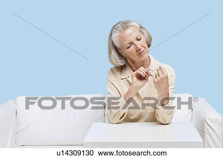 Senior woman filing nails at home View Large Photo Image Stock Image - Senior woman filing nails at home. Fotosearch