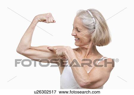 Stock Photo - Senior woman flexing muscles against white background. Fotosearch