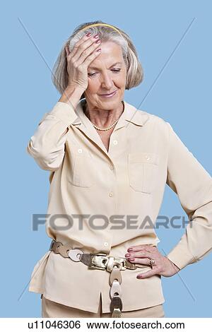 Senior woman in casuals suffering from headache against blue background View Large Photo Image Stock Photograph - Senior woman in casuals suffering from headache against blue background. Fotosearch