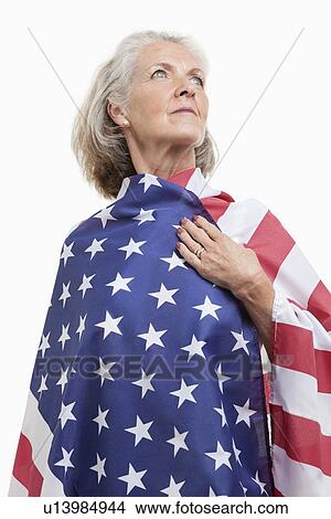 Senior woman wrapped in American flag against white background View Large Photo Image Picture - Senior woman wrapped in American flag against white background. Fotosearch