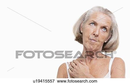 Unwell senior woman with thermometer in mouth against white background View Large Photo Image Stock Photo - Unwell senior woman with thermometer in mouth against white background. Fotosearch