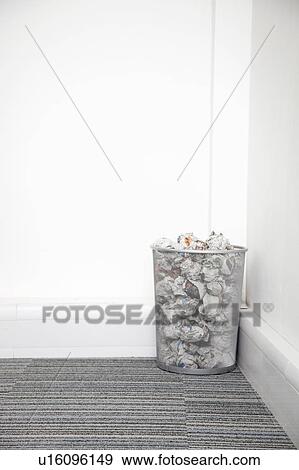 Wastebasket full of crumpled paper in corner against white wall View Large Photo Image Stock Photo - Wastebasket full of crumpled paper in corner against white wall. Fotosearch