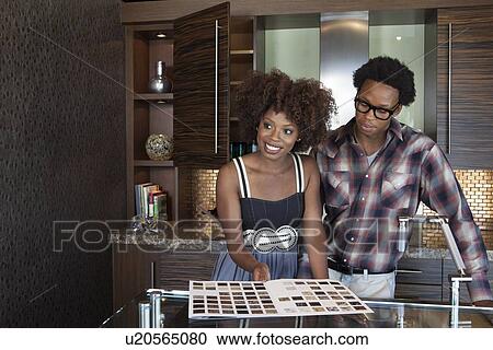 Stock Image - Young African American couple at new furnished kitchen. Fotosearch