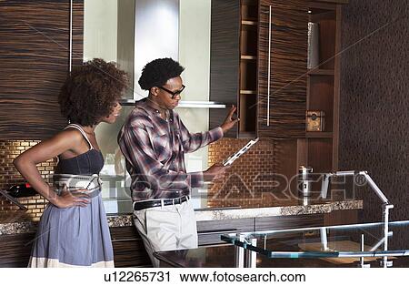 Young African American couple in new furnished Kitchen choosing materials View Large Photo Image Stock Image - Young African American couple in new furnished Kitchen choosing materials. Fotosearch