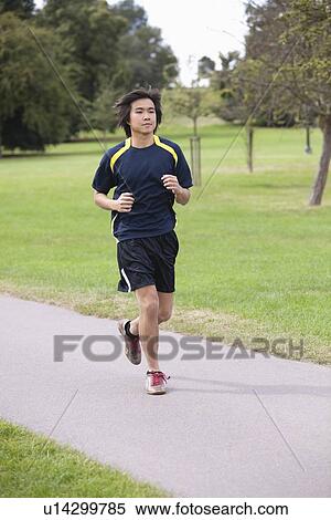 Stock Photography - Young Chinese man jogging at park. Fotosearch