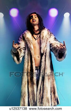 Young rock musician in fur coat making rebellious hand gestures View Large Photo Image Stock Photo - Young rock musician in fur coat making rebellious hand gestures. Fotosearch