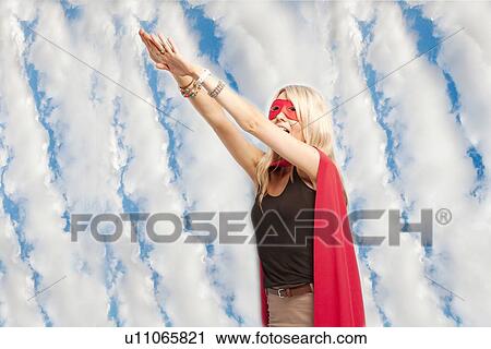 Young woman in superhero outfit taking a leap in the air against cloudy sky View Large Photo Image Stock Image - Young woman in superhero outfit taking a leap in the air against cloudy sky. Fotosearch