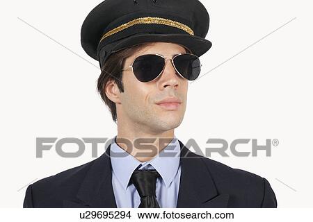 Picture - Close-up of young male pilot in uniform against white background. Fotosearch