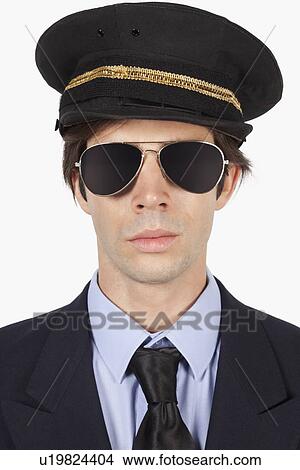 Picture - Close-up of young man in pilot uniform against white background. Fotosearch