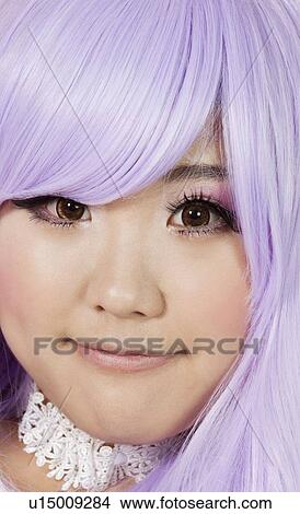 Picture - Close-up portrait of cute young woman with purple wig. Fotosearch