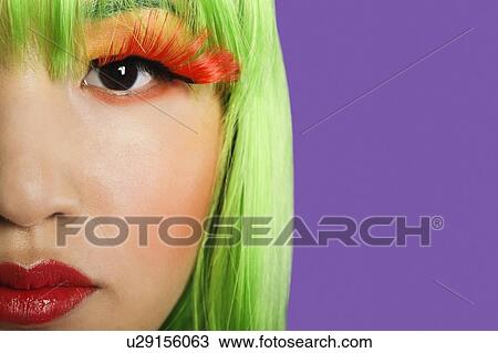 Cropped image of young woman wearing false eyelashes against purple background View Large Photo Image Stock Image - Cropped image of young woman wearing false eyelashes against purple background. Fotosearch