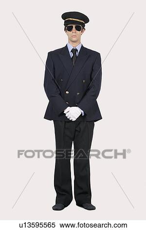 Full length of young man in pilot uniform standing against gray background View Large Photo Image Stock Photography - Full length of young man in pilot uniform standing against gray background. Fotosearch