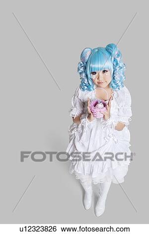 Full length portrait of cute woman in doll costume holding toy basket over gray background View Large Photo Image Stock Photograph - Full length portrait of cute woman in doll costume holding toy basket over gray background. Fotosearch