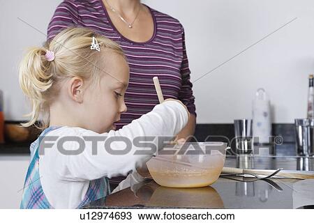 Girl and mother cooking together in kitchen View Large Photo Image Stock Image - Girl and mother cooking together in kitchen. Fotosearch