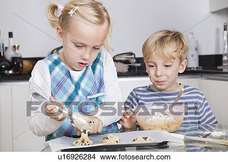 Picture - Happy brother and sister baking cookies in kitchen. Fotosearch