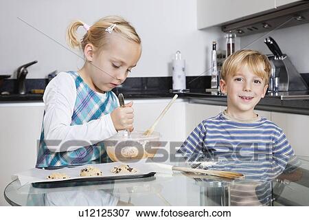 Happy brother and sister baking cookies in kitchen View Large Photo Image Stock Photo - Happy brother and sister baking cookies in kitchen. Fotosearch