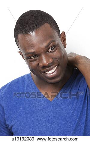 Stock Photo - Happy young African American man looking away against white background. Fotosearch