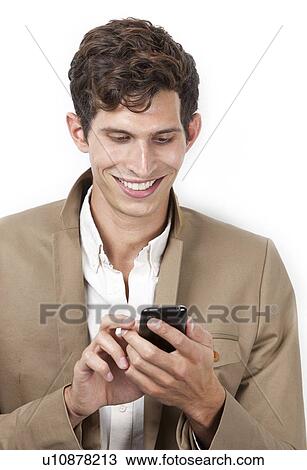 Happy young man text messaging against white background View Large Photo Image Stock Image - Happy young man text messaging against white background. Fotosearch