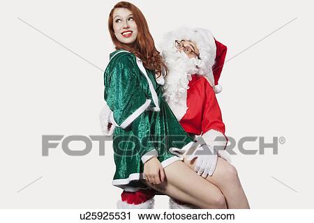 Happy young woman sitting on Santa's laps against gray background View Large Photo Image Stock Image - Happy young woman sitting on Santa's laps against gray background. Fotosearch