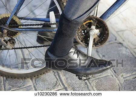 Low section of businessman riding bicycle on street View Large Photo Image Stock Photograph - Low section of businessman riding bicycle on street. Fotosearch