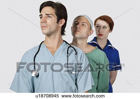 Medical practitioners standing together against gray background View Large Photo Image Stock Photography - Medical practitioners standing together against gray background. Fotosearch