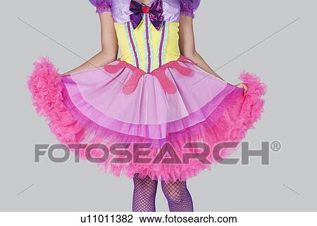 Midsection of young woman in doll's costume standing against gray background View Large Photo Image Stock Image - Midsection of young woman in doll's costume standing against gray background. Fotosearch