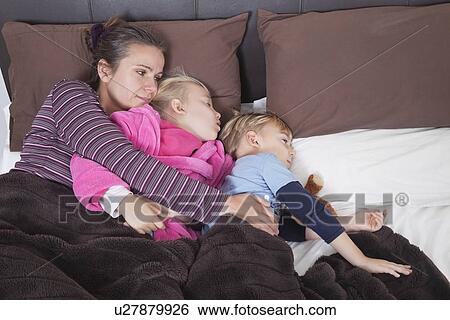 Mother lying in bed with two children View Large Photo Image Stock Photograph - Mother lying in bed with two children. Fotosearch