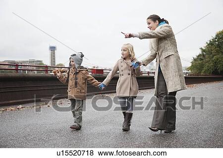 Mother points out something in the distance to children View Large Photo Image Stock Photo - Mother points out something in the distance to children. Fotosearch
