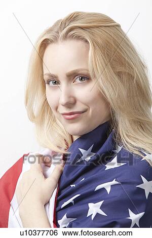 Portrait of beautiful young Caucasian woman wrapped in American flag against white background View Large Photo Image Stock Photograph - Portrait of beautiful young Caucasian woman wrapped in American flag against white background. Fotosearch