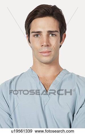 Portrait of confident young man in surgical scrubs over gray background View Large Photo Image Stock Photo - Portrait of confident young man in surgical scrubs over gray background. Fotosearch