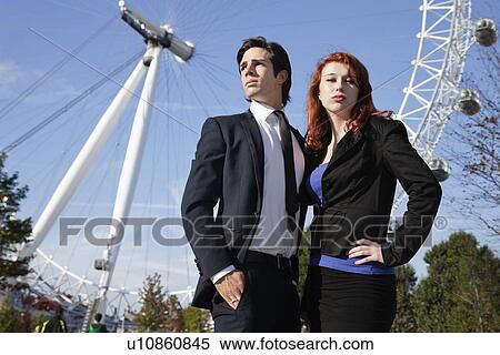 Portrait of confident young businesswoman standing against London Eye with colleague, London, UK View Large Photo Image Stock Photography - Portrait of confident young businesswoman standing against London Eye with colleague, London, UK. Fotosearch