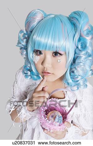 Portrait of cute woman in doll costume holding toy basket over gray background View Large Photo Image Stock Image - Portrait of cute woman in doll costume holding toy basket over gray background. Fotosearch