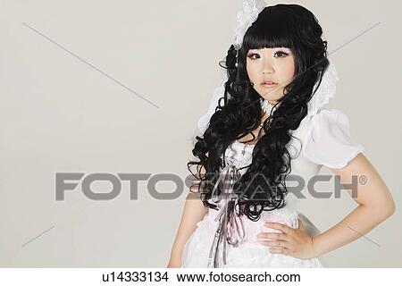 Portrait of cute young woman in doll costume standing over gray background View Large Photo Image Picture - Portrait of cute young woman in doll costume standing over gray background. Fotosearch