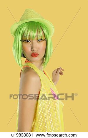 Portrait of funky young woman with green hair puckering her lips against yellow background View Large Photo Image Stock Image - Portrait of funky young woman with green hair puckering her lips against yellow background. Fotosearch