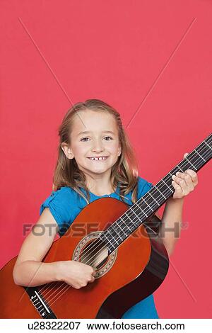 Portrait of girl playing guitar against red background View Large Photo Image Stock Photo - Portrait of girl playing guitar against red background. Fotosearch