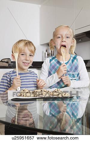 Portrait of happy boy with sister tasting spatula mix with cookie batter in kitchen View Large Photo Image Stock Photo - Portrait of happy boy with sister tasting spatula mix with cookie batter in kitchen. Fotosearch