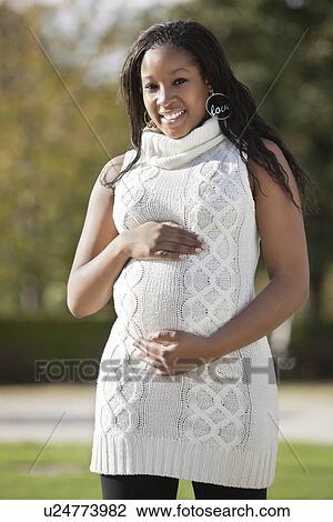 Portrait of happy young pregnant woman in park View Large Photo Image Stock Image - Portrait of happy young pregnant woman in park. Fotosearch